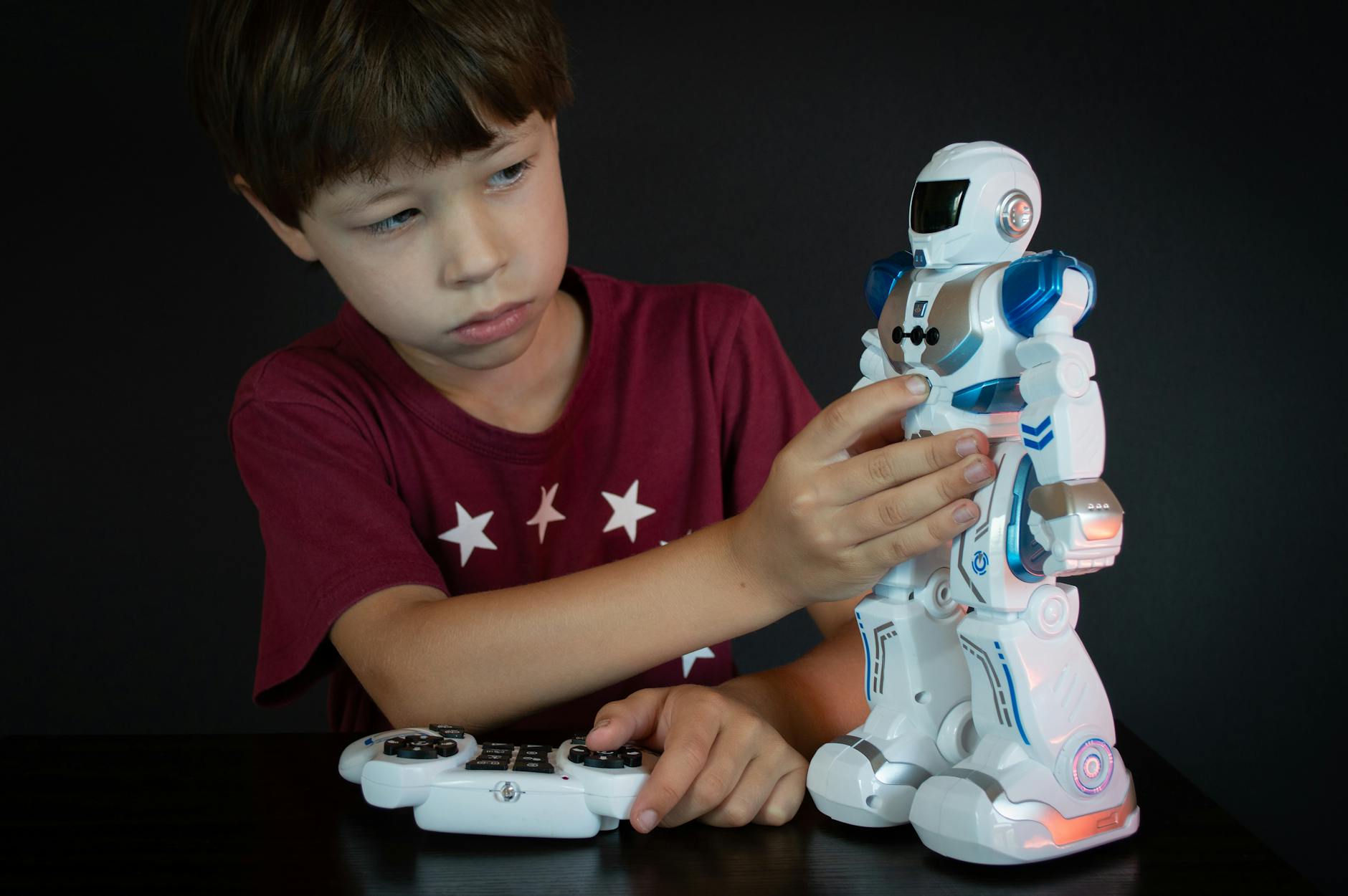Enfant souriant assis au sol avec un chien robot quadrupède, ambiance douce, lumière naturelle